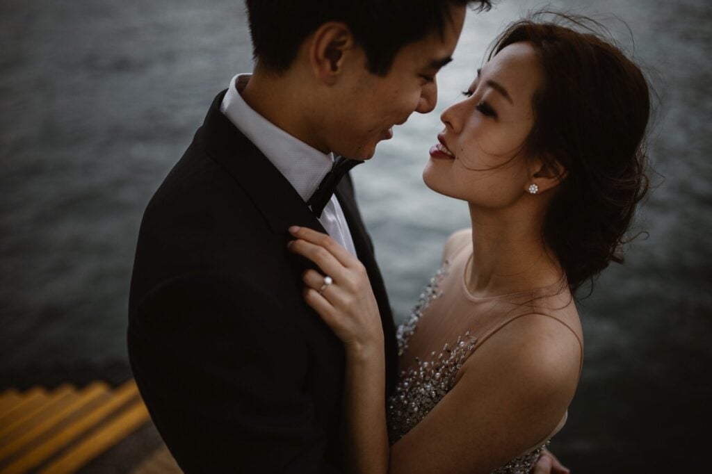 Couple in evening wear going into kiss during portrait shoot at Hong Kong's Victoria Harbour