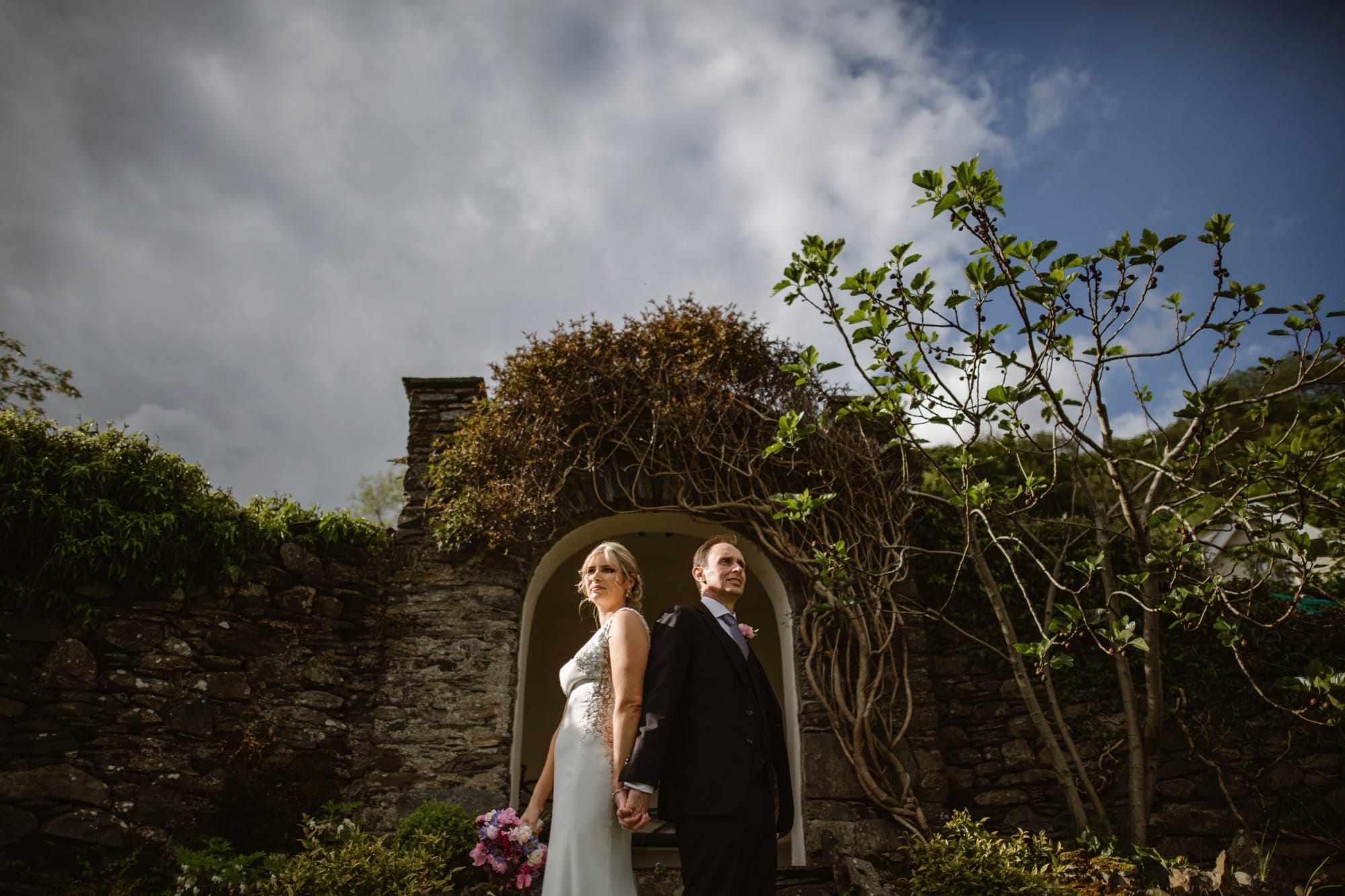 Bride & Groom in the grounds of The Samling Hotel by a brick archway