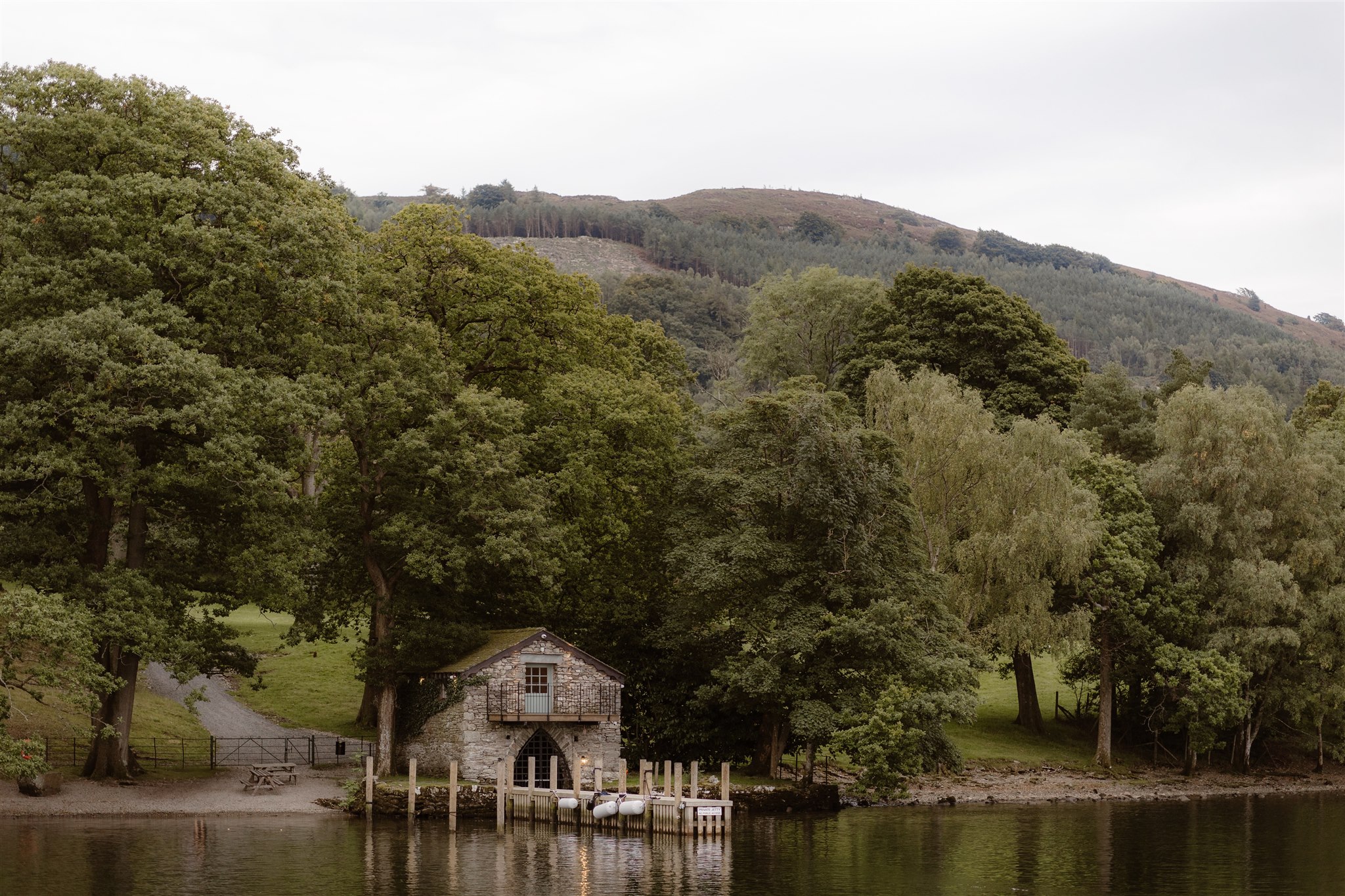 Exterior shot of The Boat House at Town Head Estate. Taken from Lake Windermere showing it set in the green grounds