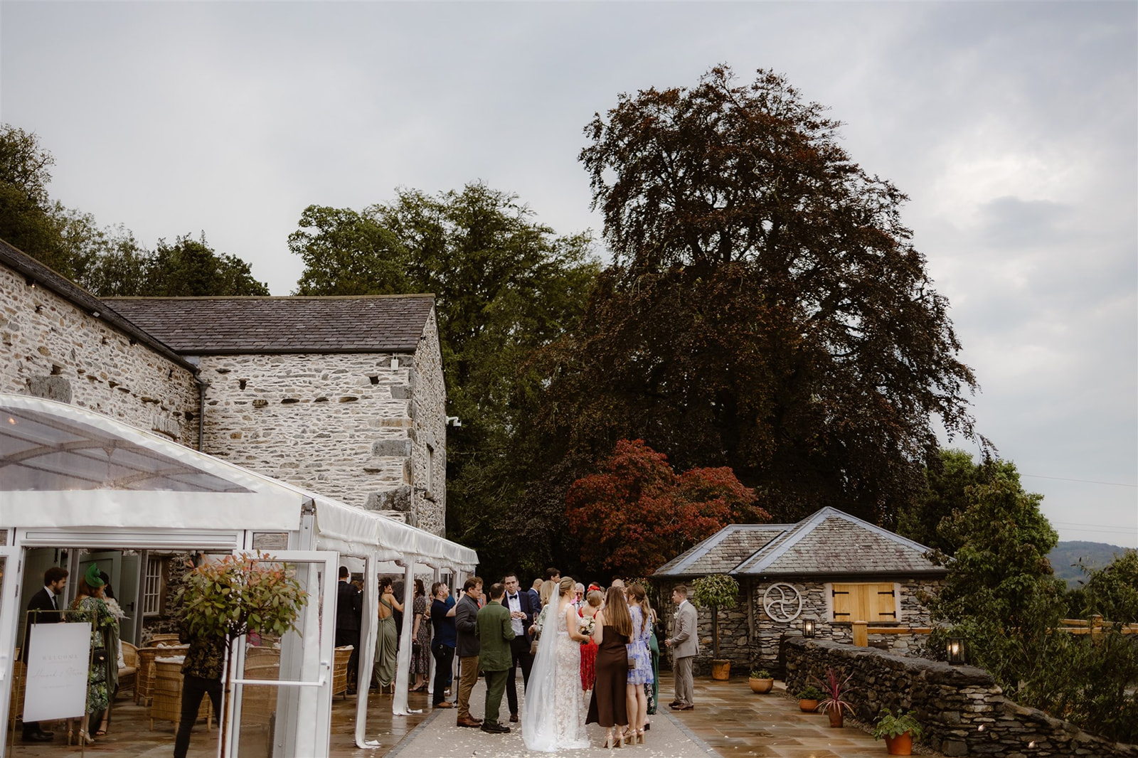 Guests stood on terrace and inside Marquee at Town Head Estate's wedding barn