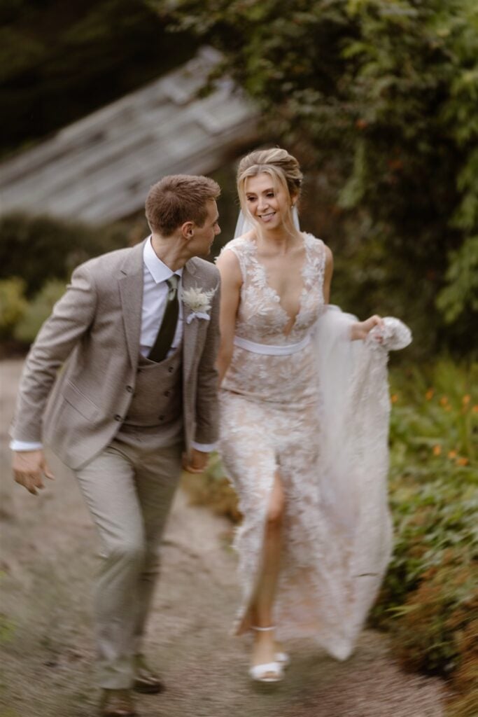 Bride and groom walking joyfully outdoors.