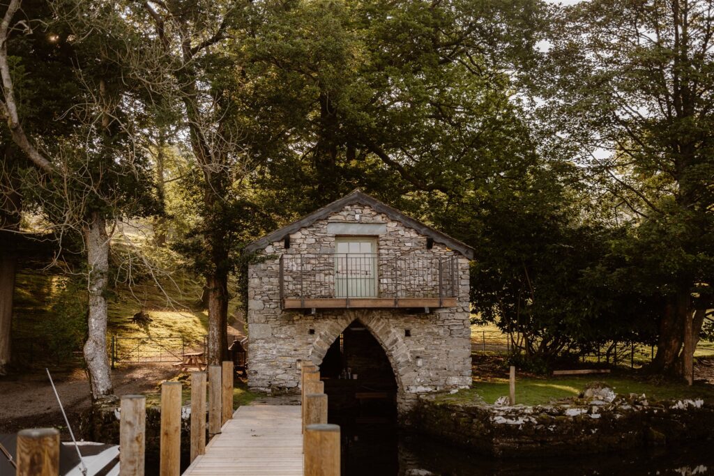 Old stone boathouse by a wooden pier.