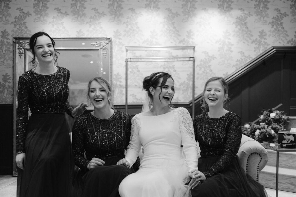 Bride and bridesmaids laughing together.