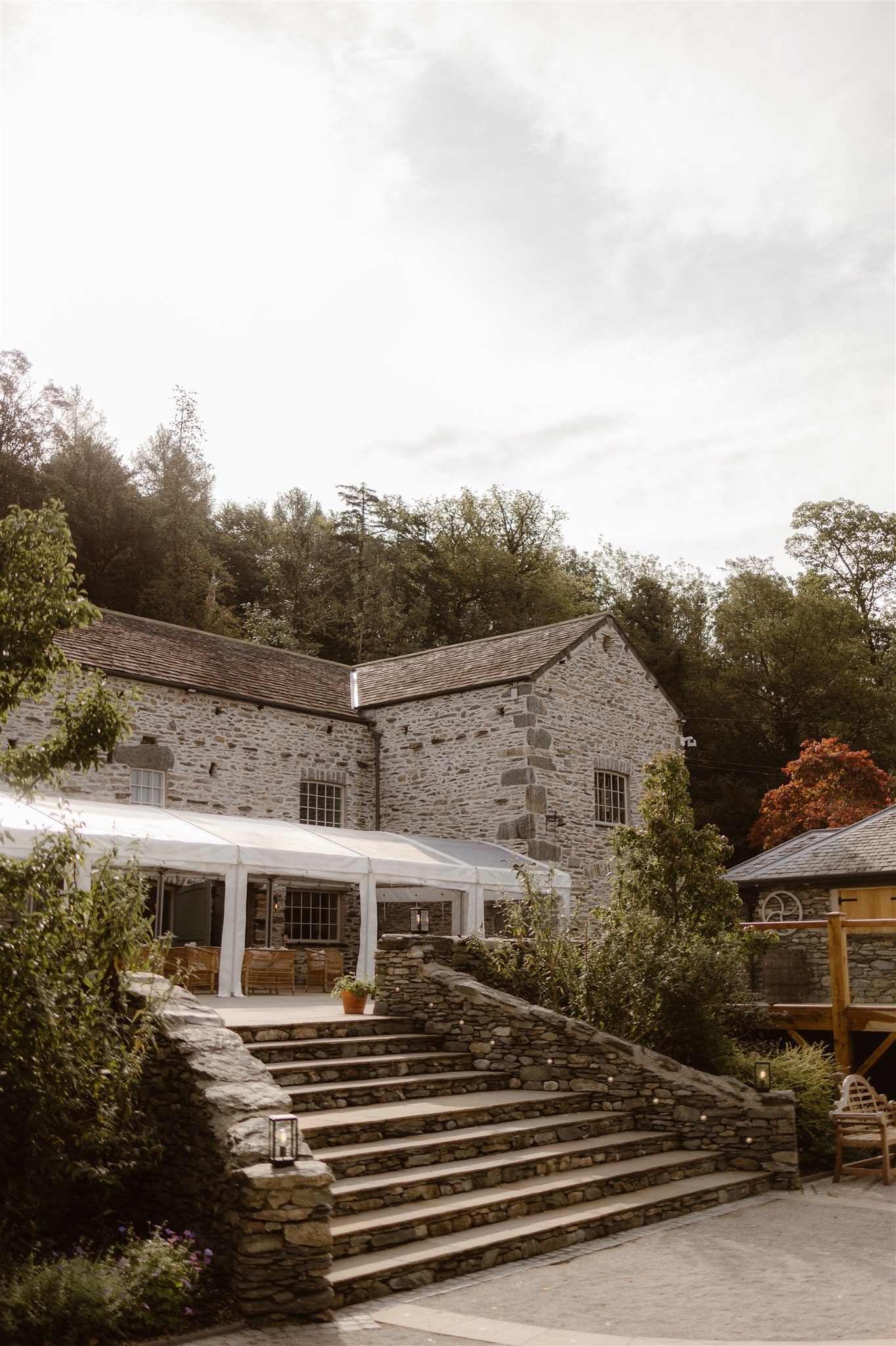 External shot of Town Head Estate showing steps up to the stone barn with a marquee extension.