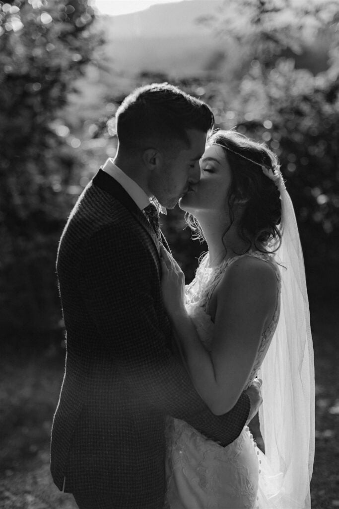 Bride and groom kissing outdoors