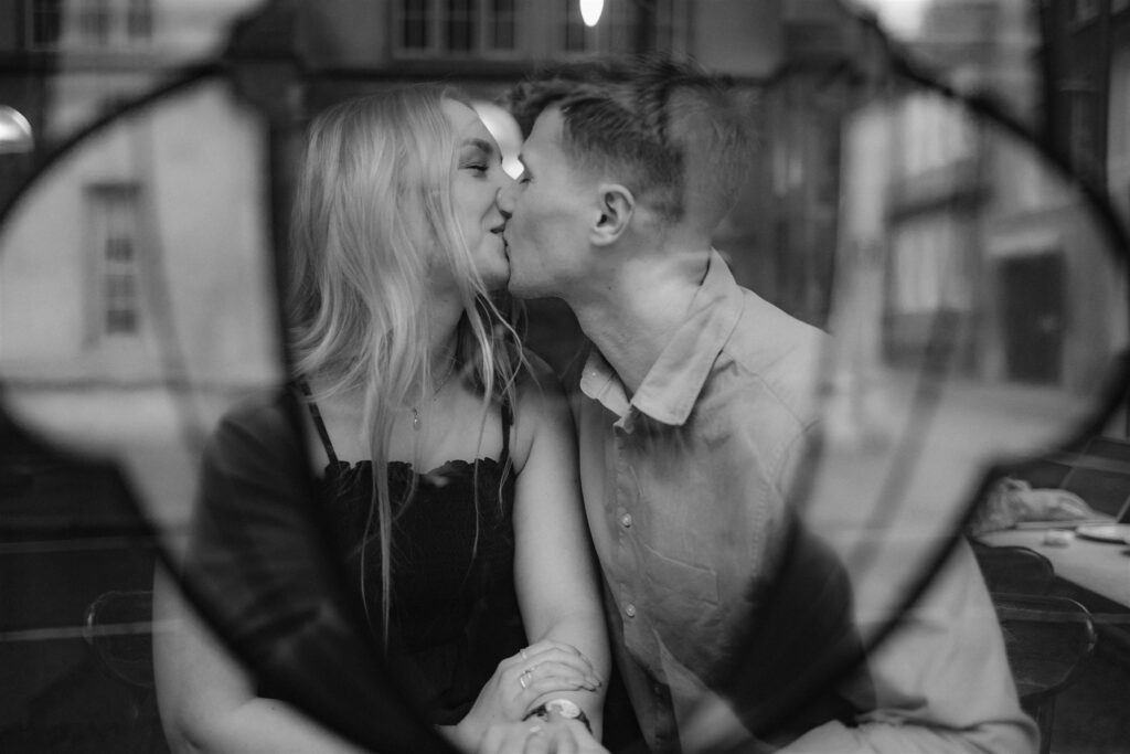 Couple on engagement shoot caught kissing through a window