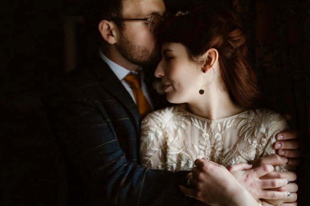 Groom kissing head of his bride