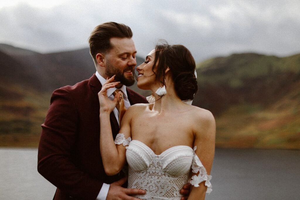 Bride leaning over shoulder to kiss husband during their elopement