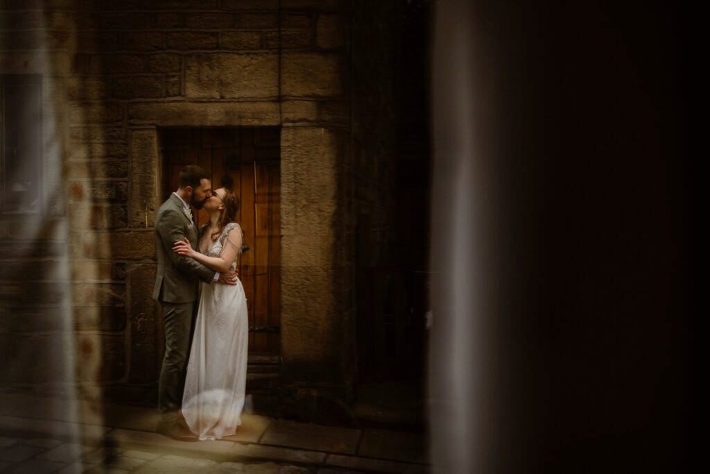 Couple after their elopement captured kissing through a window