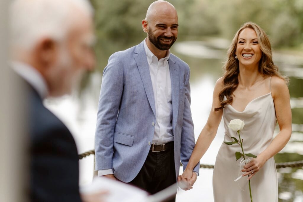 Couple during their elopement holding hands in front of officiant