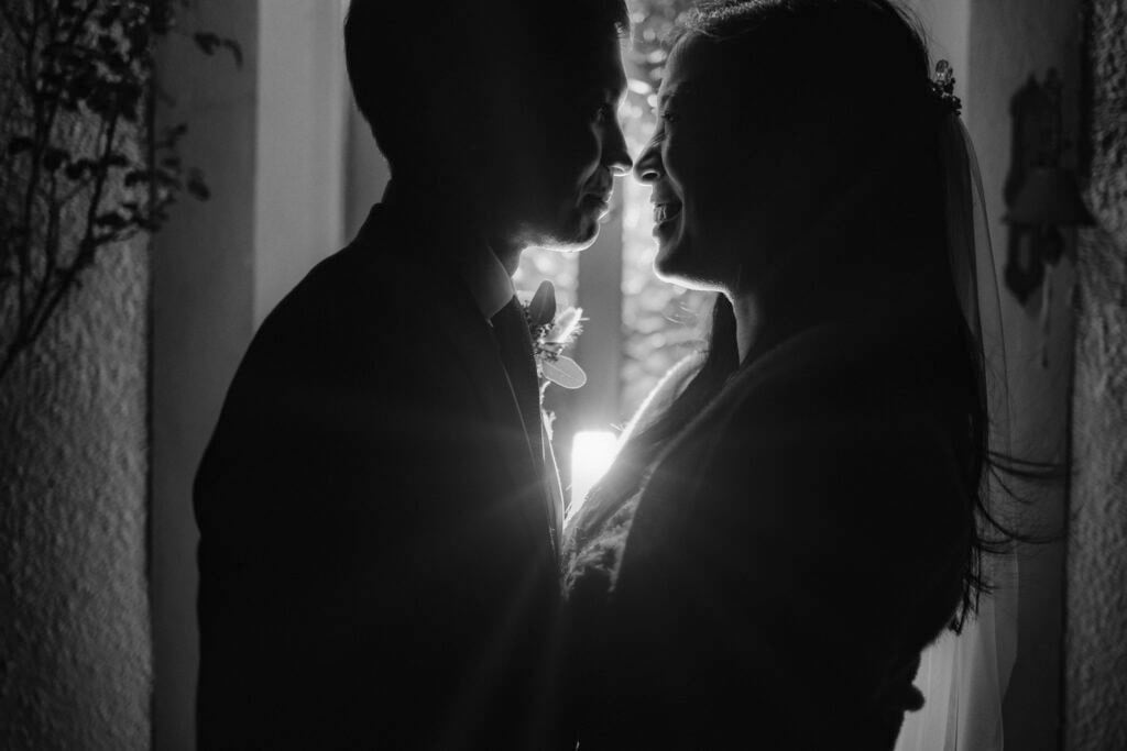 Couple silhouetted in window morning of their elopement