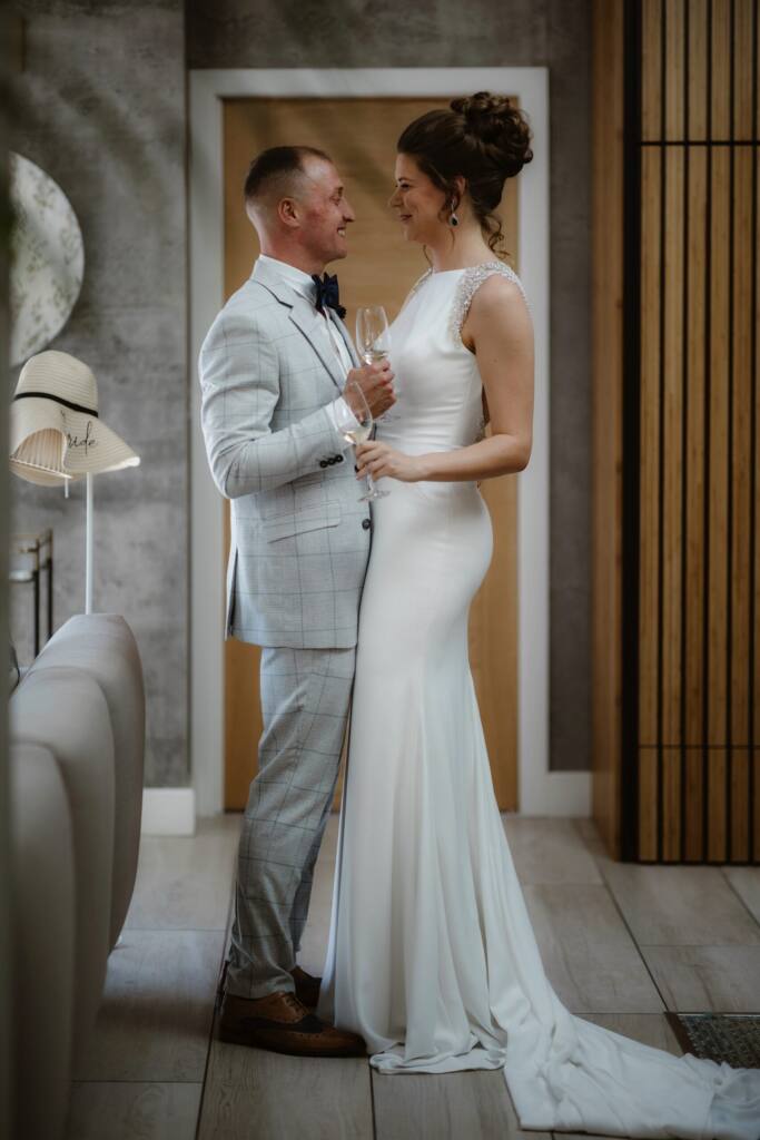 Bride & Groom embracing drinking champagne the morning of their elopement.