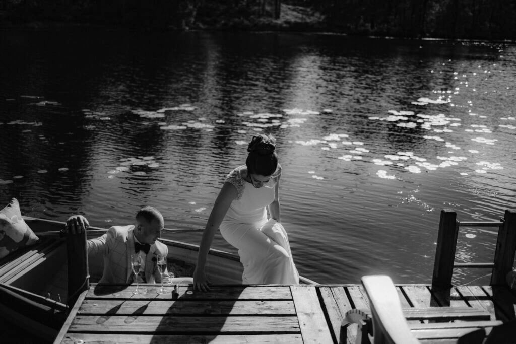 Bride stepping out of small rowing boat for her elopement ceremony