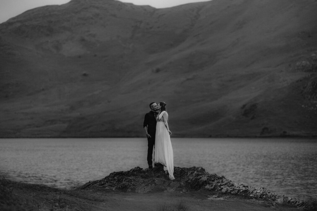 Couple kissing with Lake and Mountain in background during their elopement