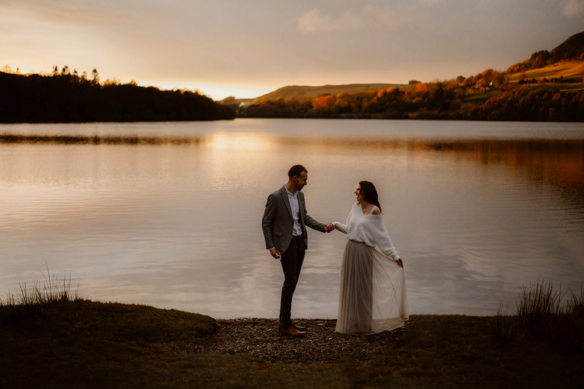 Couple dancing on shores of lake at sunset during their pre-wedding shoot