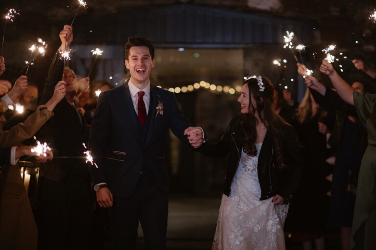 Bride & Groom walking out to guests holding sparklers