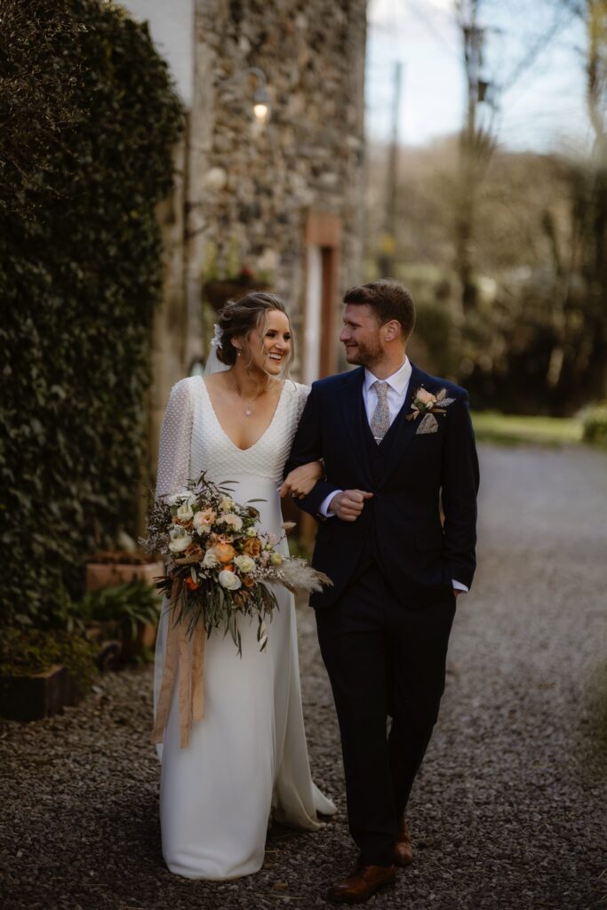 Couple walking arm-in-arm down gravel path
