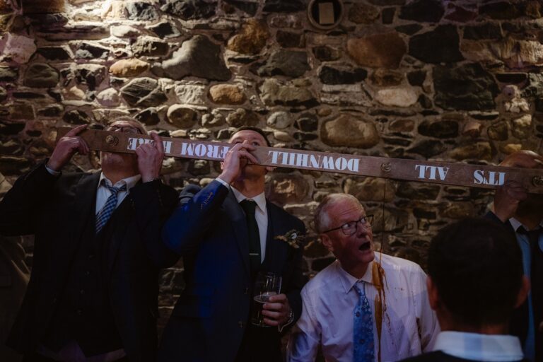 Wedding Guests doing ski shot challenge and man missing his so pours on shirt