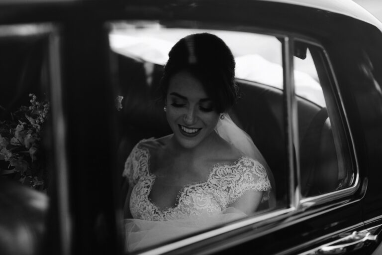 Bride sat in the car smiling before getting out