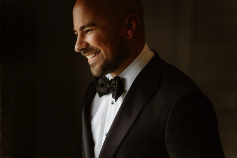 Portrait of a Groom wearing a tuxedo laughing