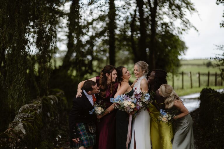 Bride and bridesmaids photographed laughing during formal photos