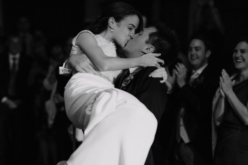 Groom picking up & kissing bride during the first dance at their small and intimate wedding