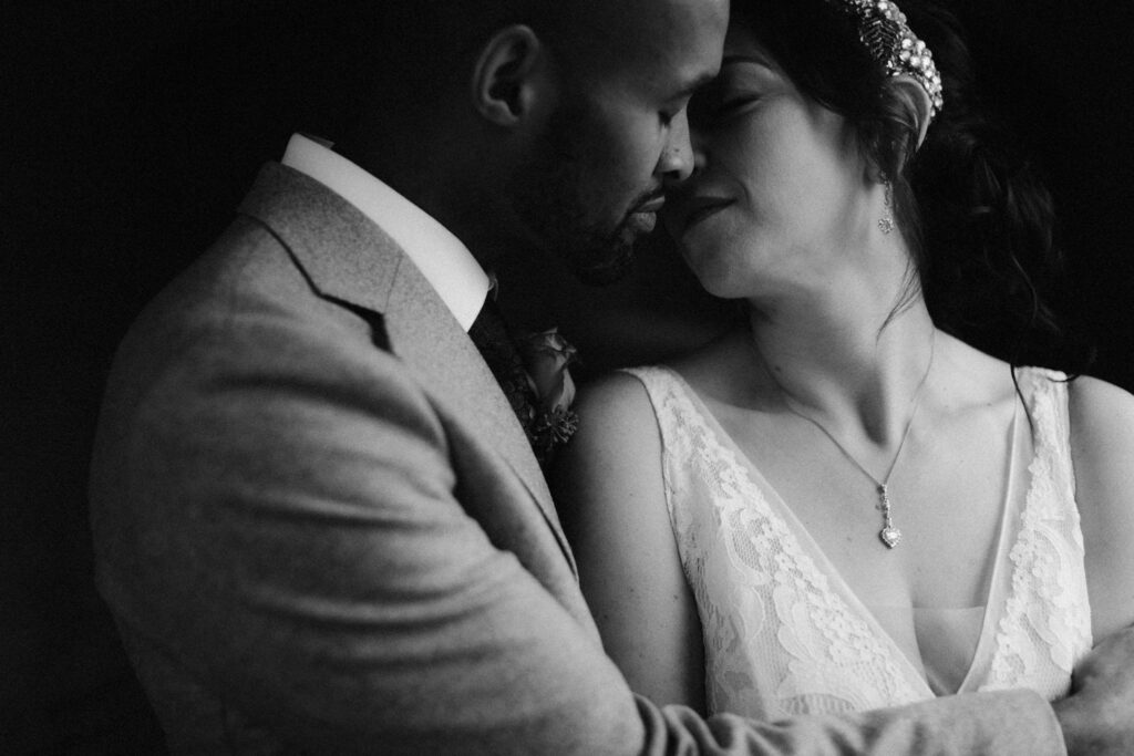 Groom holding wife in his arms as they are about to kiss