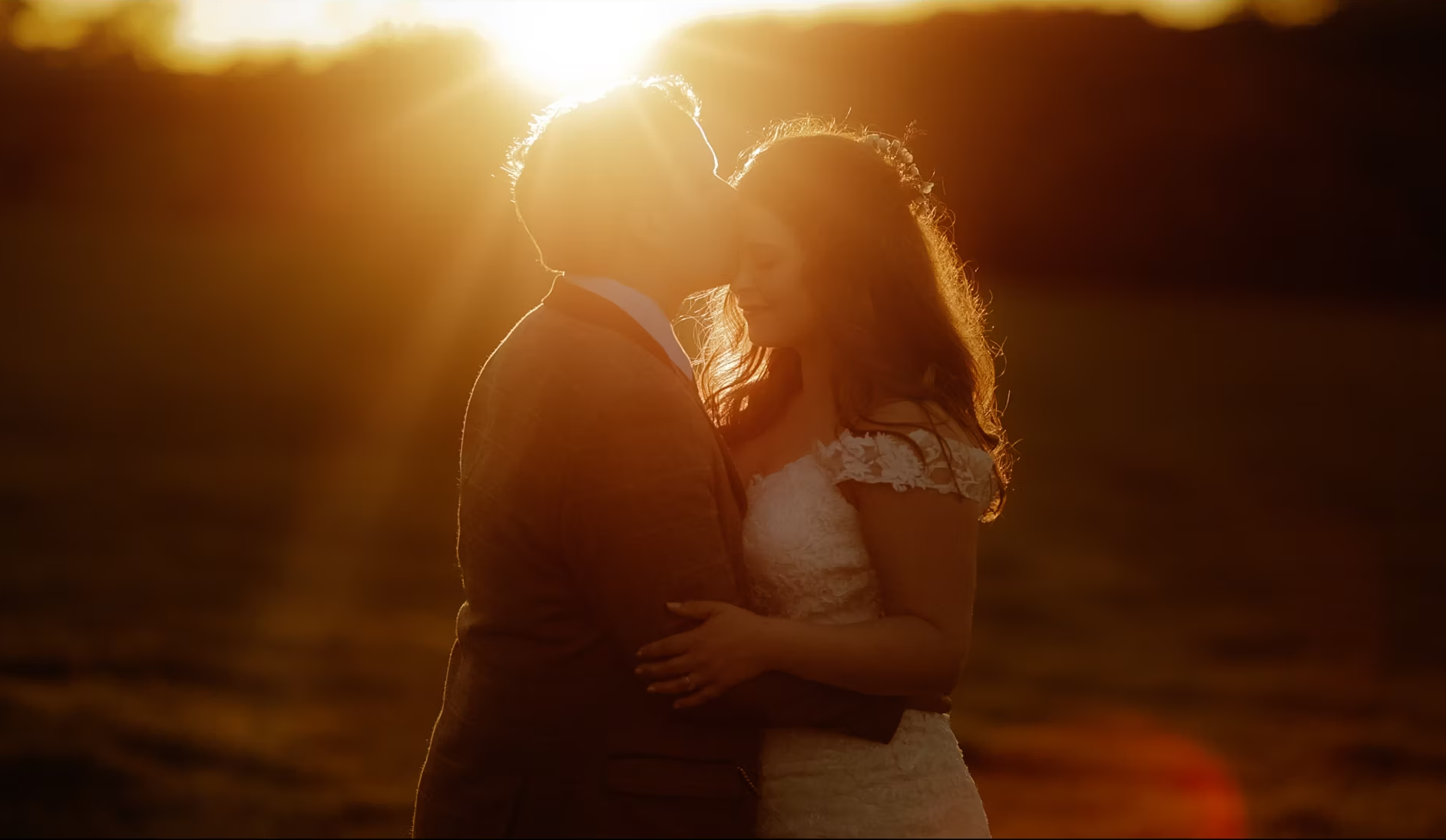 Couple embracing during sunset in grounds of Low Hall