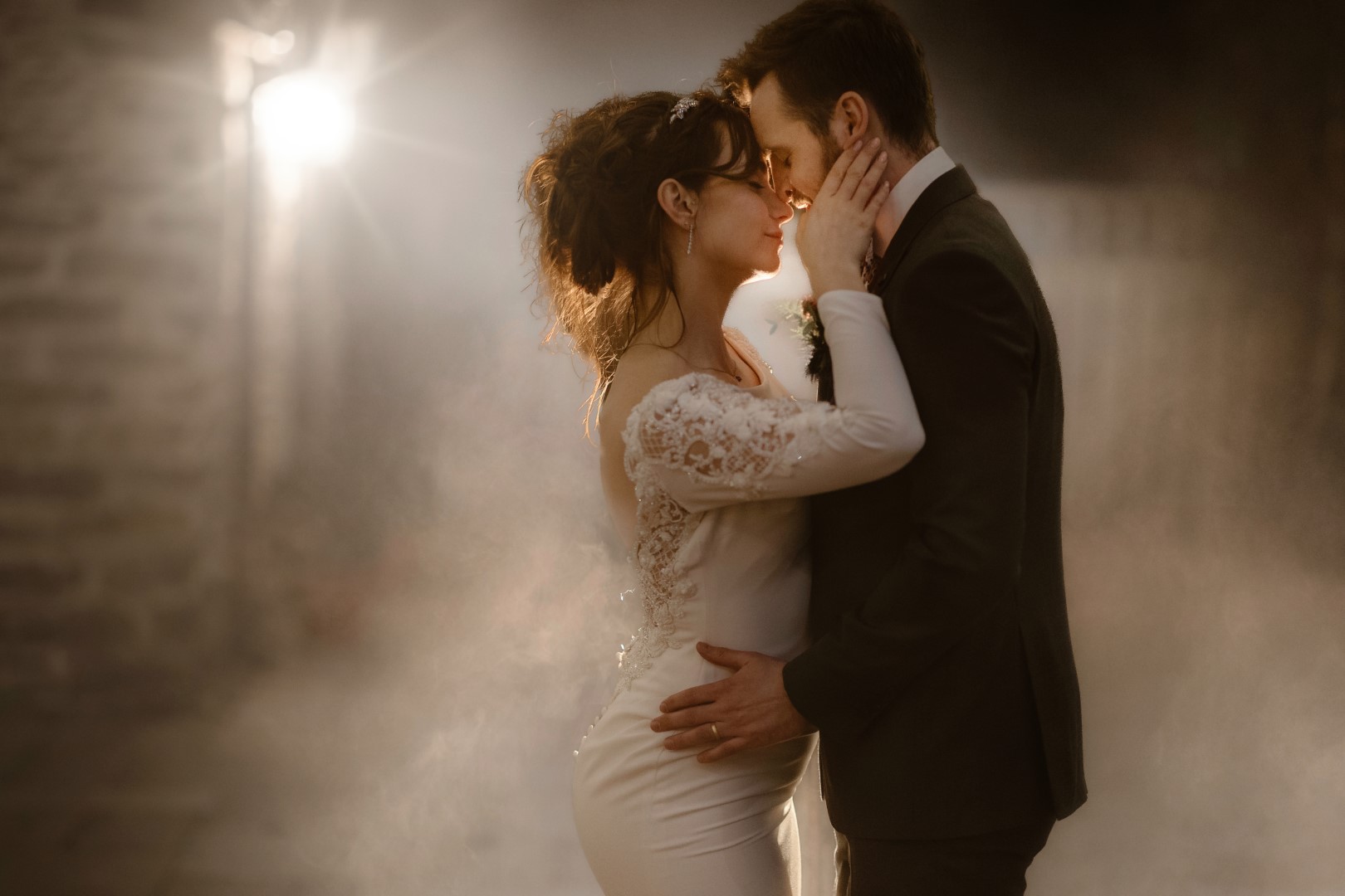 Image of couple kissing on wedding day in mist