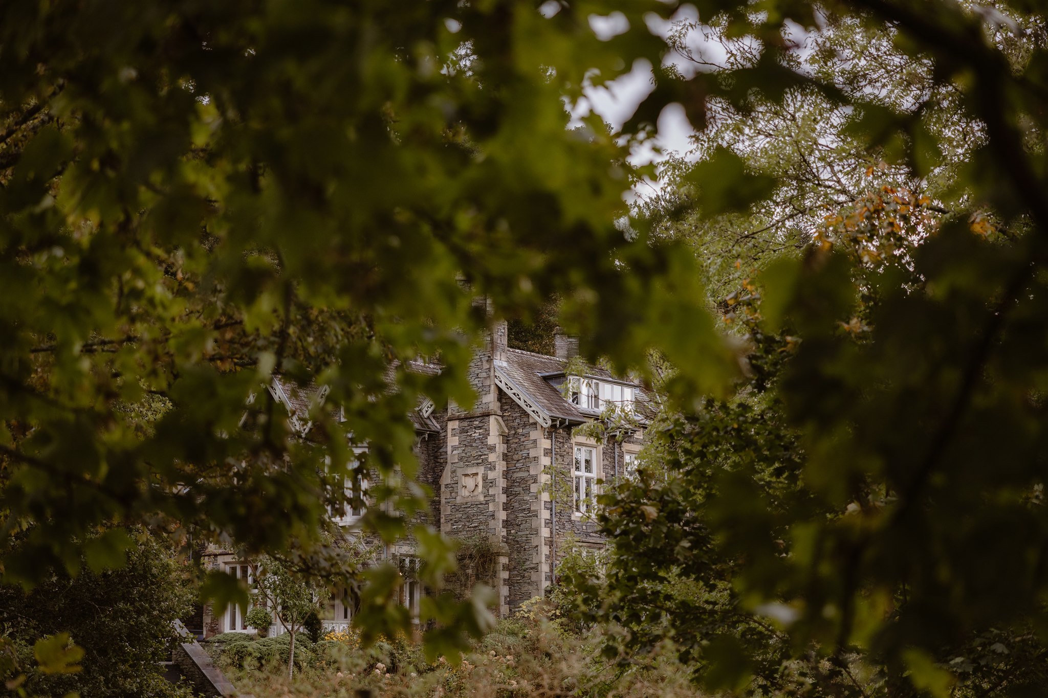 External shot of the historic wedding venue - The Forest Side in Grasmere surrounded by lush greenery.