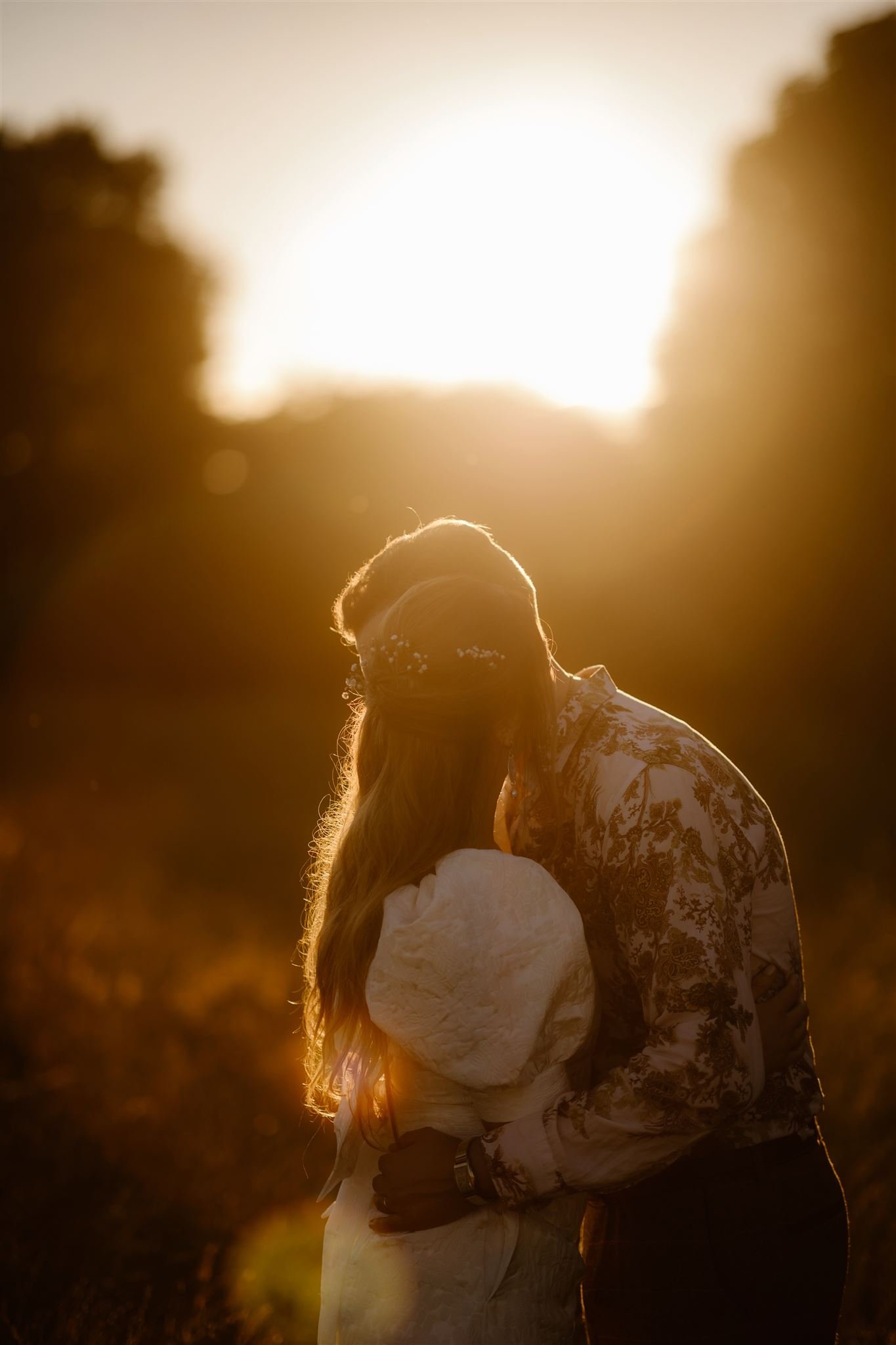 Couple embracing at sunset in nature.