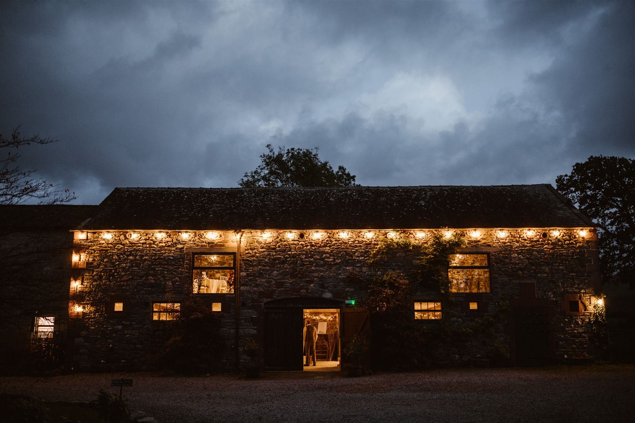 Rustic barn with warm lights at dusk.