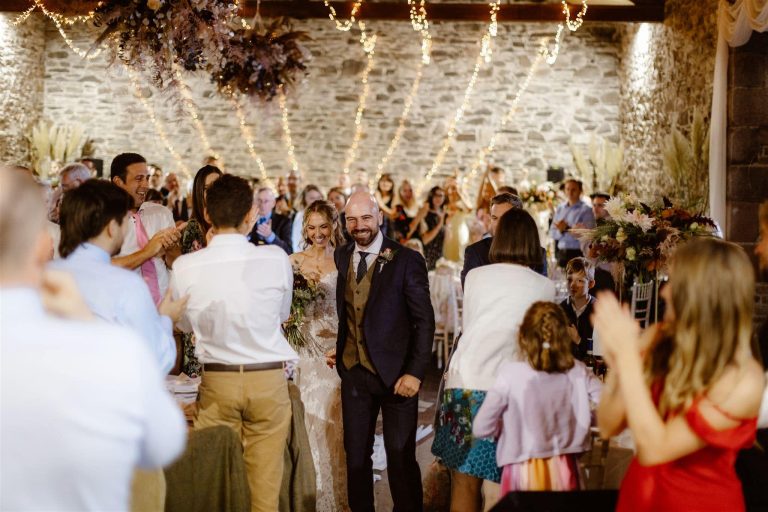 Couple leaving ceremony as guests clap