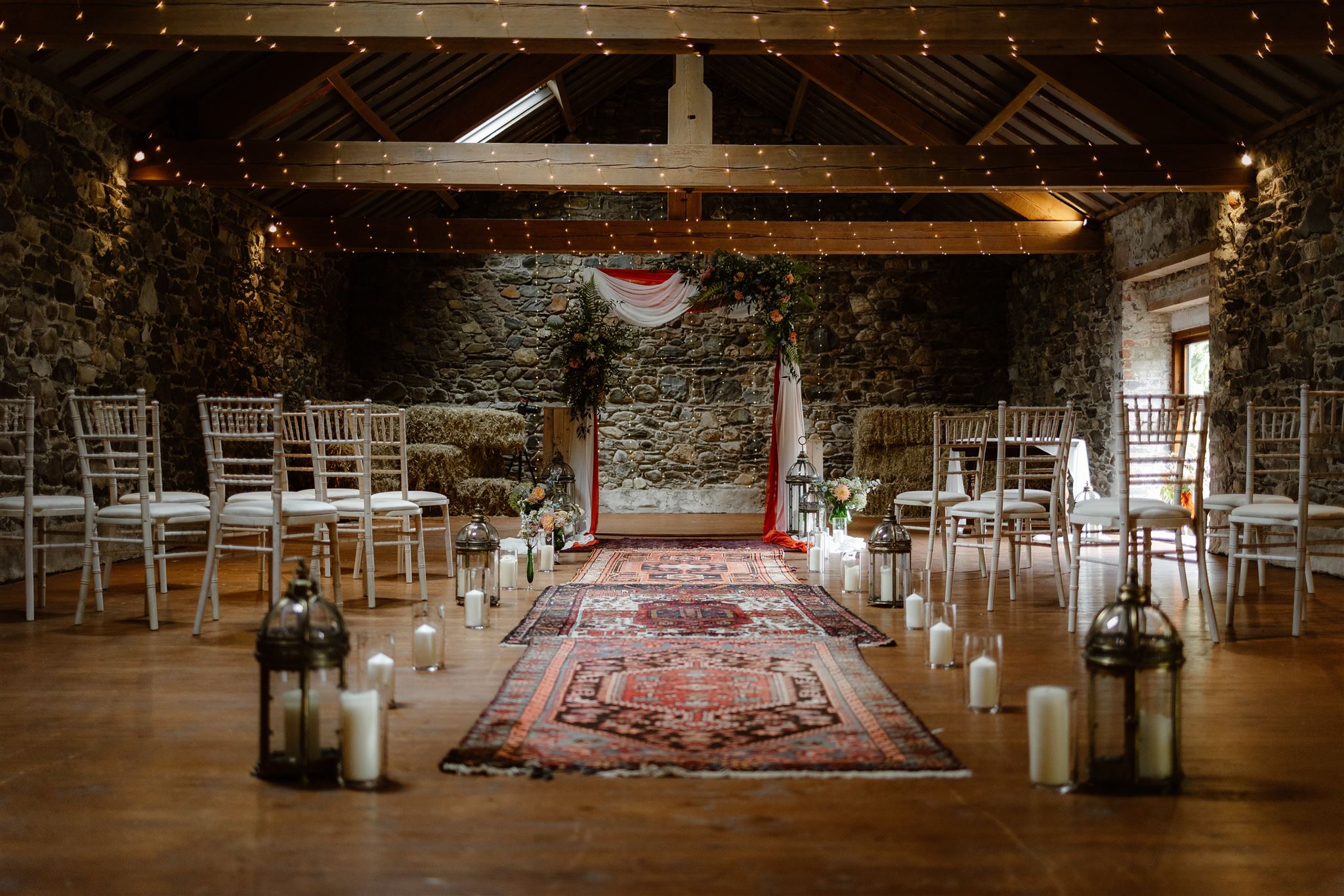 Rustic wedding ceremony setup with candles and floral decorations.