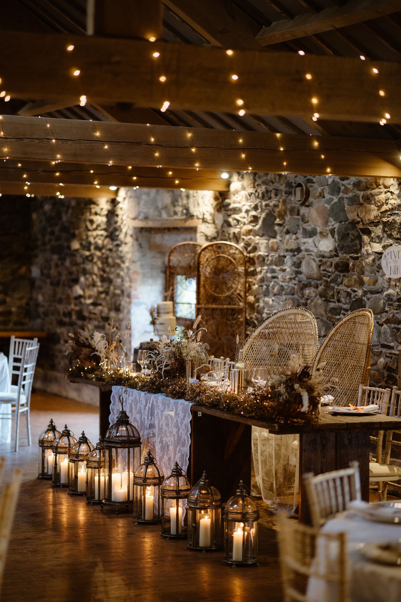 Rustic wedding table with twinkling fairy lights and lanterns.